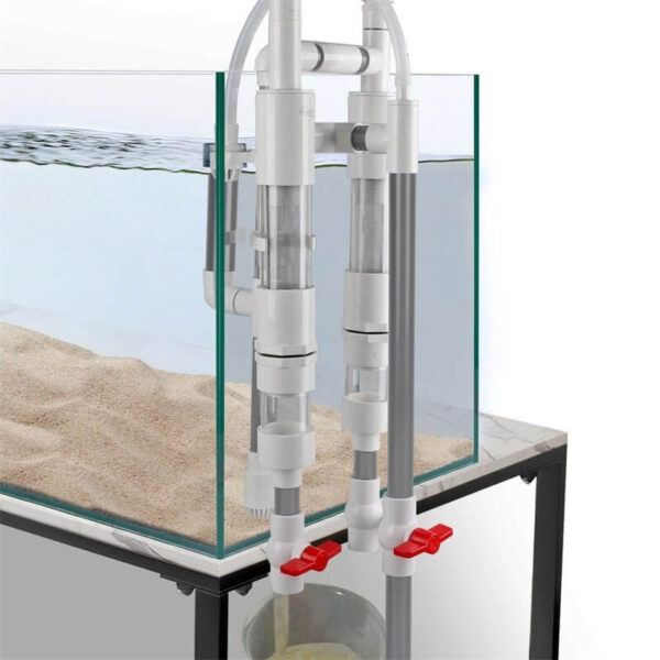 Close-up of aquarium sump filter pipes with water flowing through red valve taps